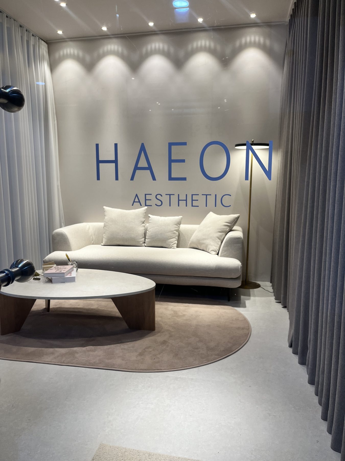 HAEON AESTHETIC 사인과 소파·러그가 보이는 라운지 전경