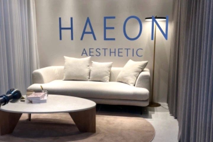 HAEON AESTHETIC 사인과 소파·테이블이 있는 라운지 전경